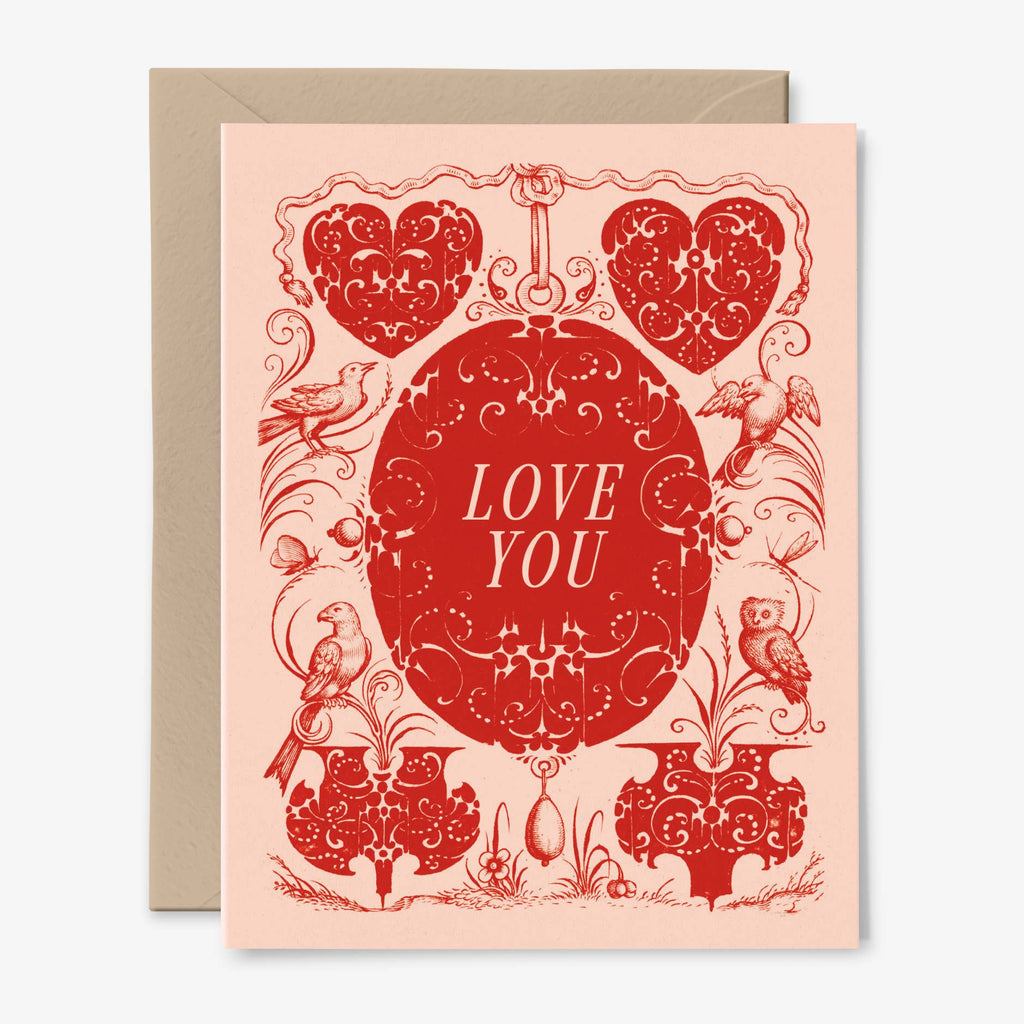 A pale pink card illustrated with red gothic style hearts, birds, insects, and flourishes with the words "Love You."