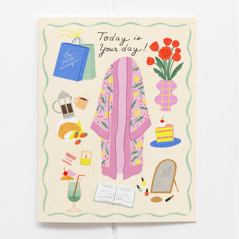 A cream card that says "Today is Your Day!" and is illustrated with self care essentials such as a colorful robe, flowers, cake, makeup, books, cocktails, croissants, fruit, a French press, and shopping bags.