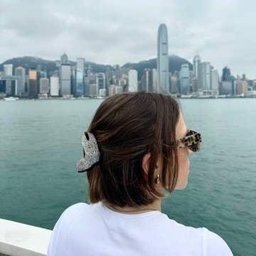 A person wearing the Cowboy Boot Hair Clip to hold up their hair in a half-up hairstyle.