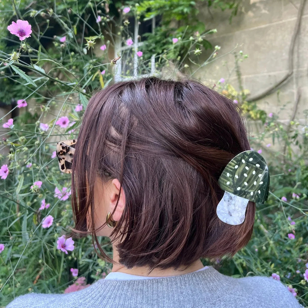 A person holding up their half-up hairstyle with an evergreen Toadstool Mushroom Claw Clip.