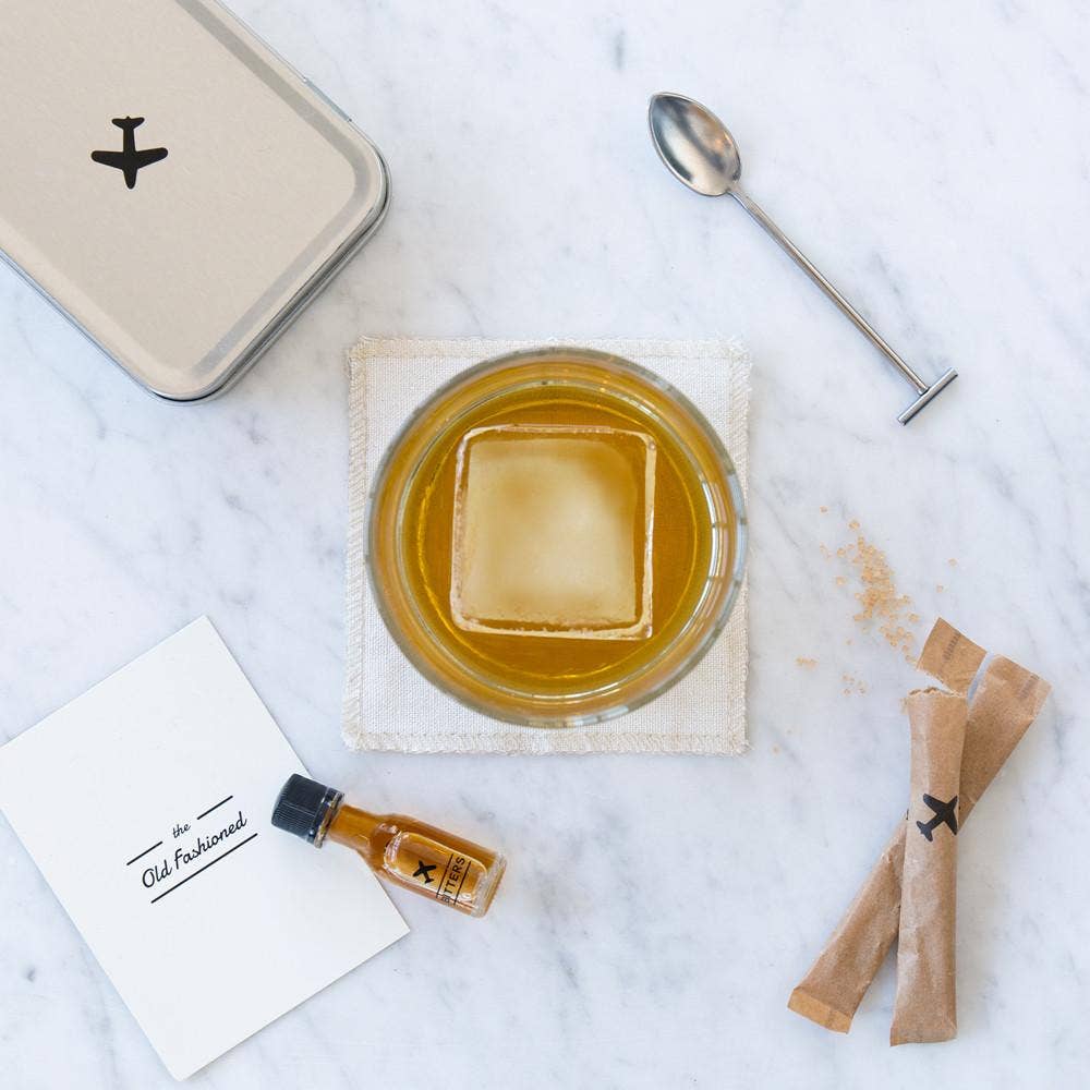 A bird's eye view of an Old Fashioned Cocktail next to a variety of ingredients included in the cocktail kit.