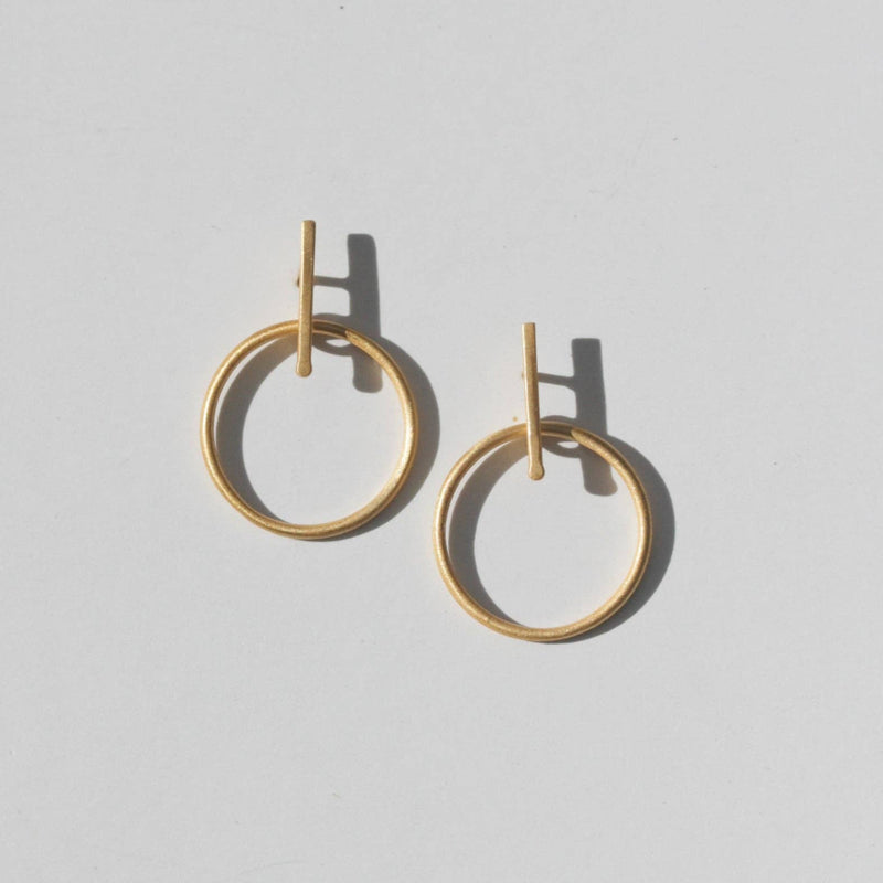 Two gold brass stud earrings with a vertical bar and a hanging hoop.