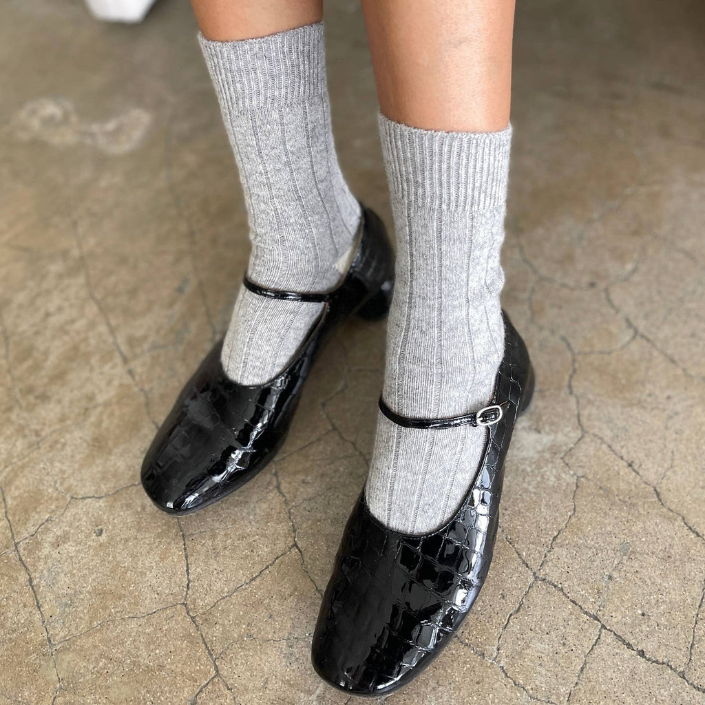 A person wearing the Classic Cashmere Socks with black mary jane heels.