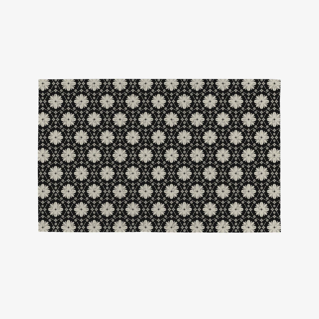 A black Not Paper Towel geometrically patterned with white flowers.