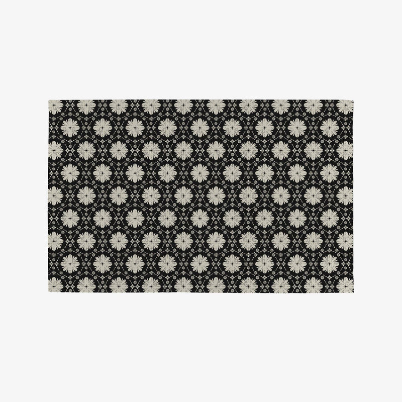 A black Not Paper Towel geometrically patterned with white flowers.