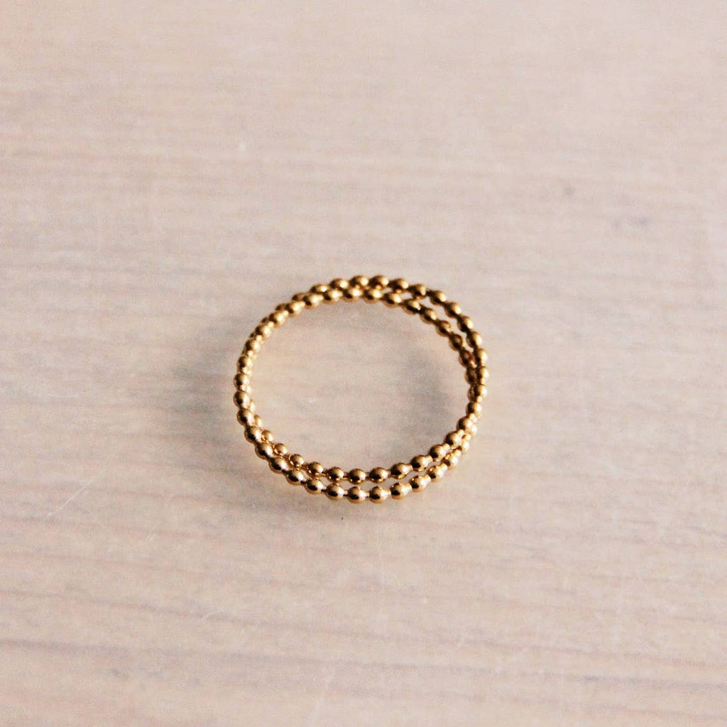 Two rings overlapped with one another decorated with tiny gold balls.