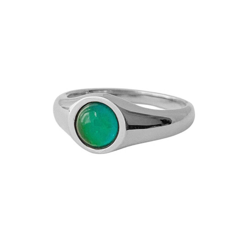 A close-up of the Signet Mood Ring in Silver transitioning from teal to green.