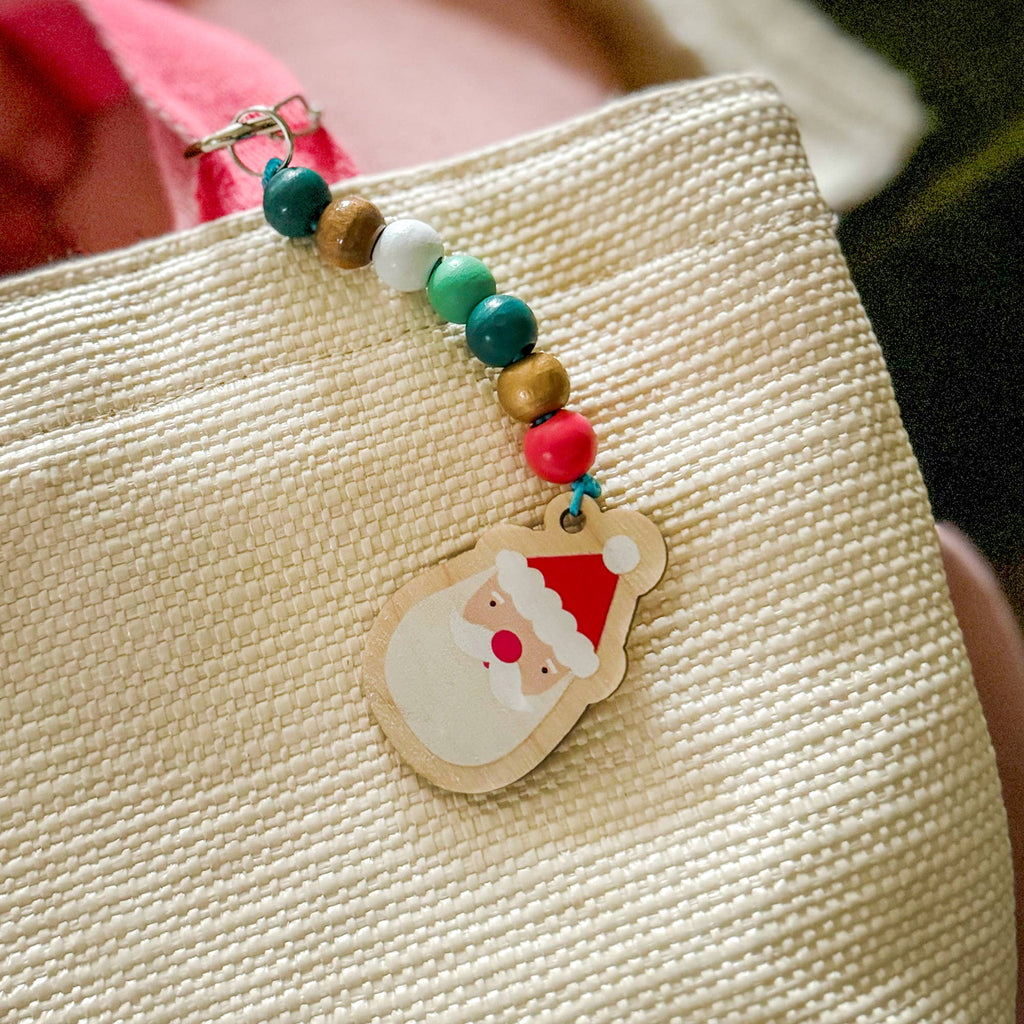 A keychain with a string of wooden beads ending in a santa claus pendant.