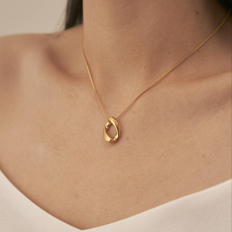 A fine gold plated stainless steel chain  with a twisted loop pendant made of the same material.