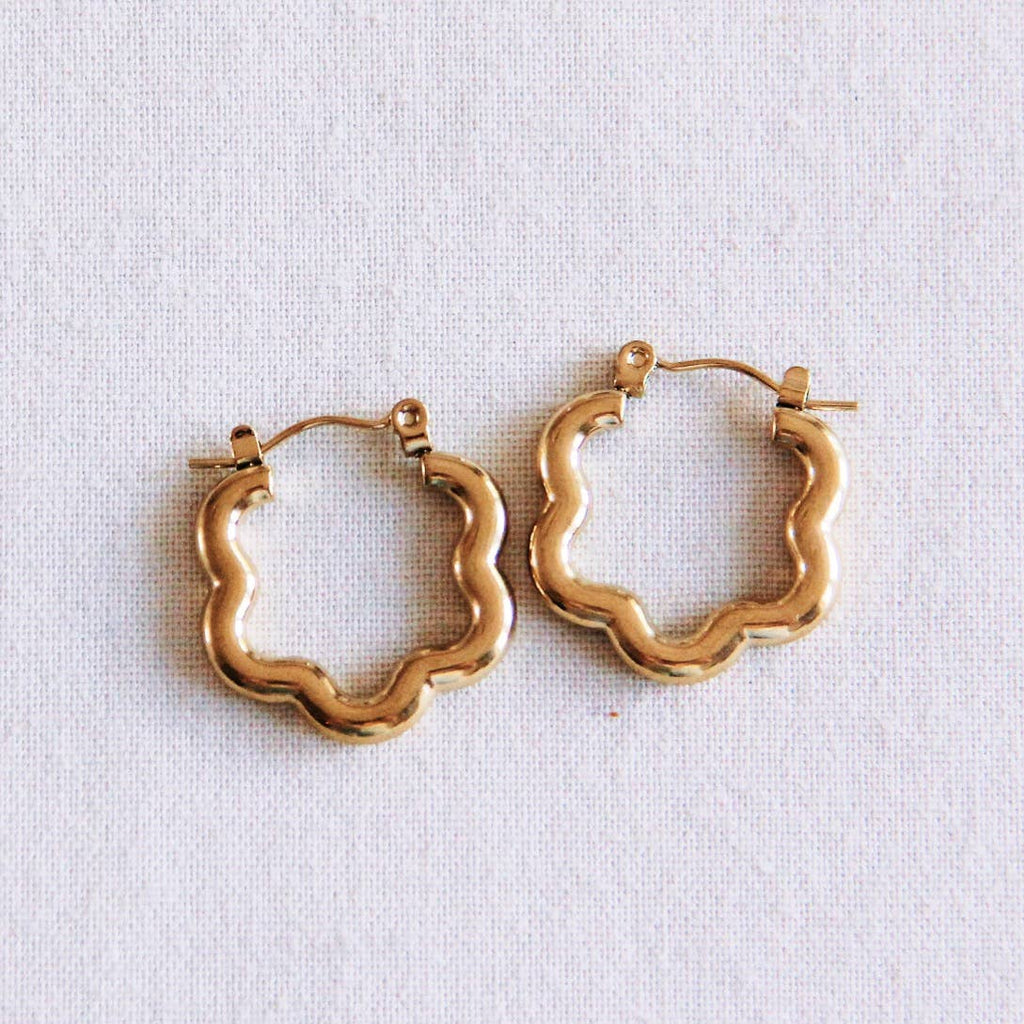 Two gold stainless steel hoops that make a 70's flower shape and secures with a latch closure.