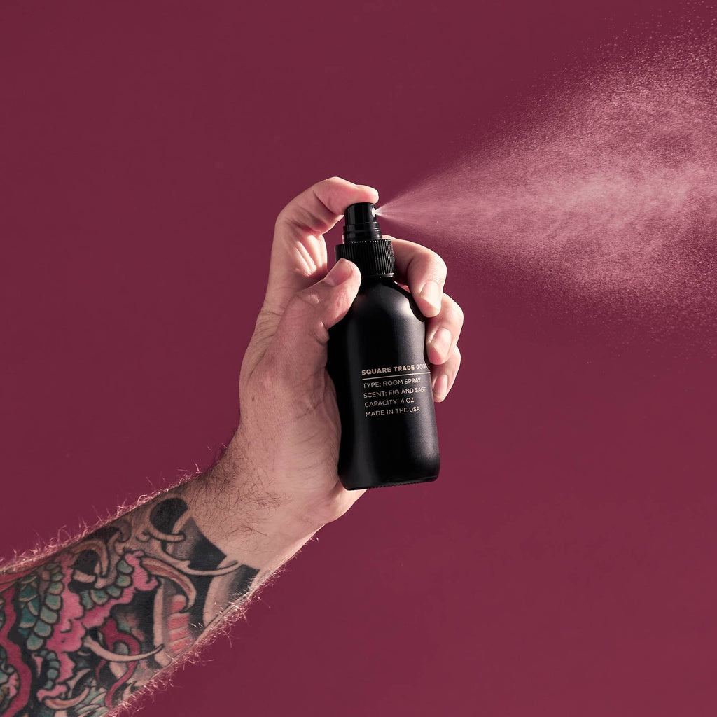 A hand spraying Fig & Sage Room Spray into the air.