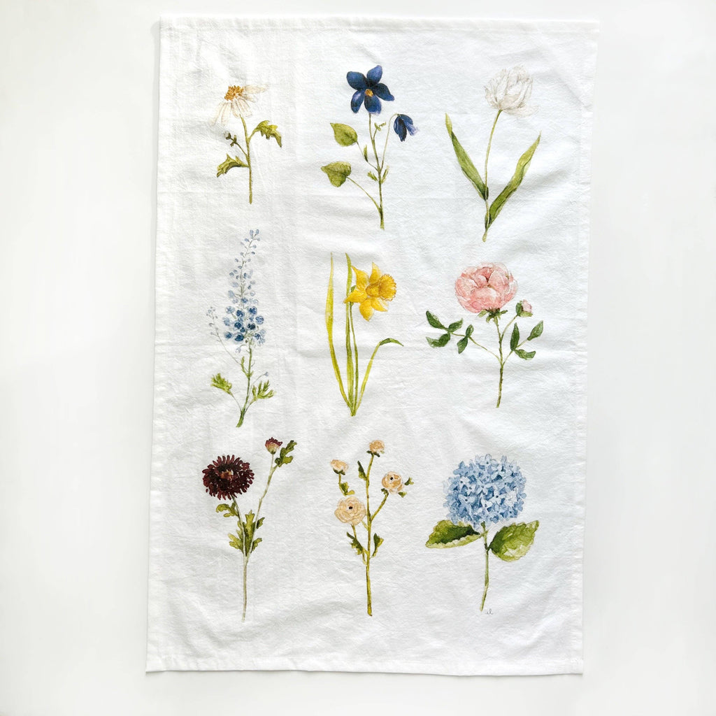 A white towel illustrated with nine watercolor flowers.