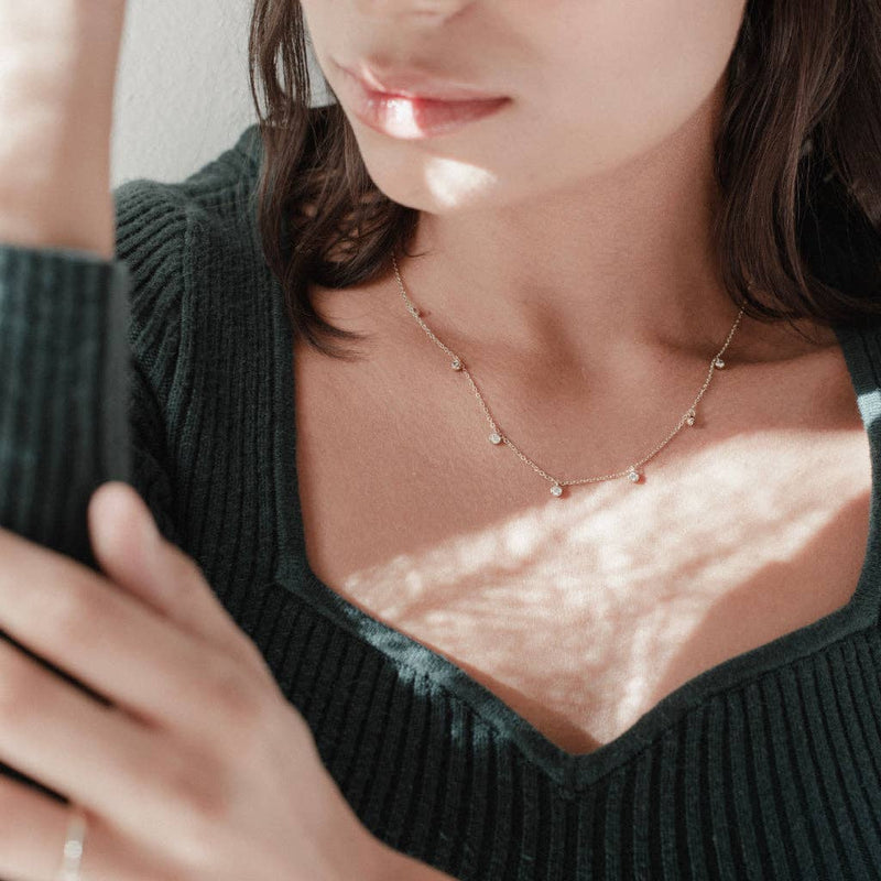 A person wearing the Crystal Stardust Necklace in a silver colorway.