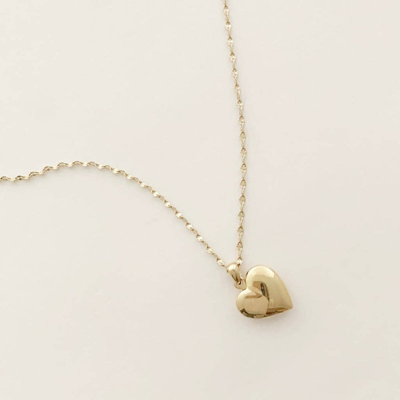 A gold plated heart locket pendant on a fine chain necklace.