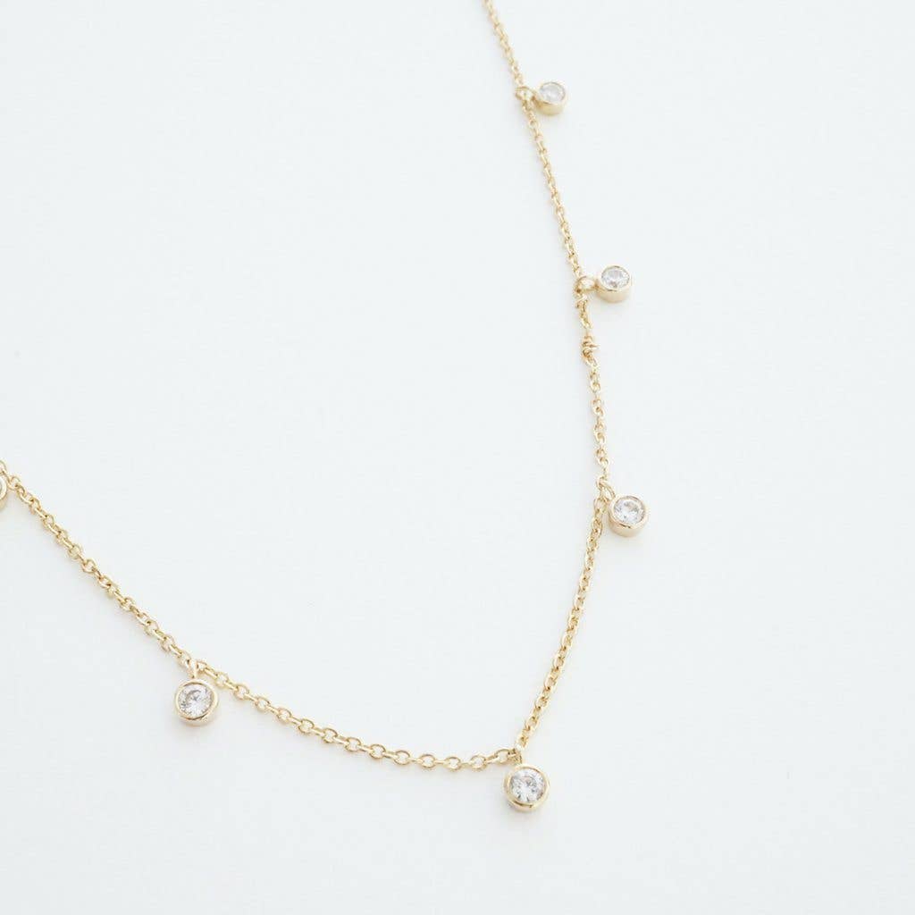 A delicate gold plated chain necklace with dainty clear white gems equally dispersed around its length.