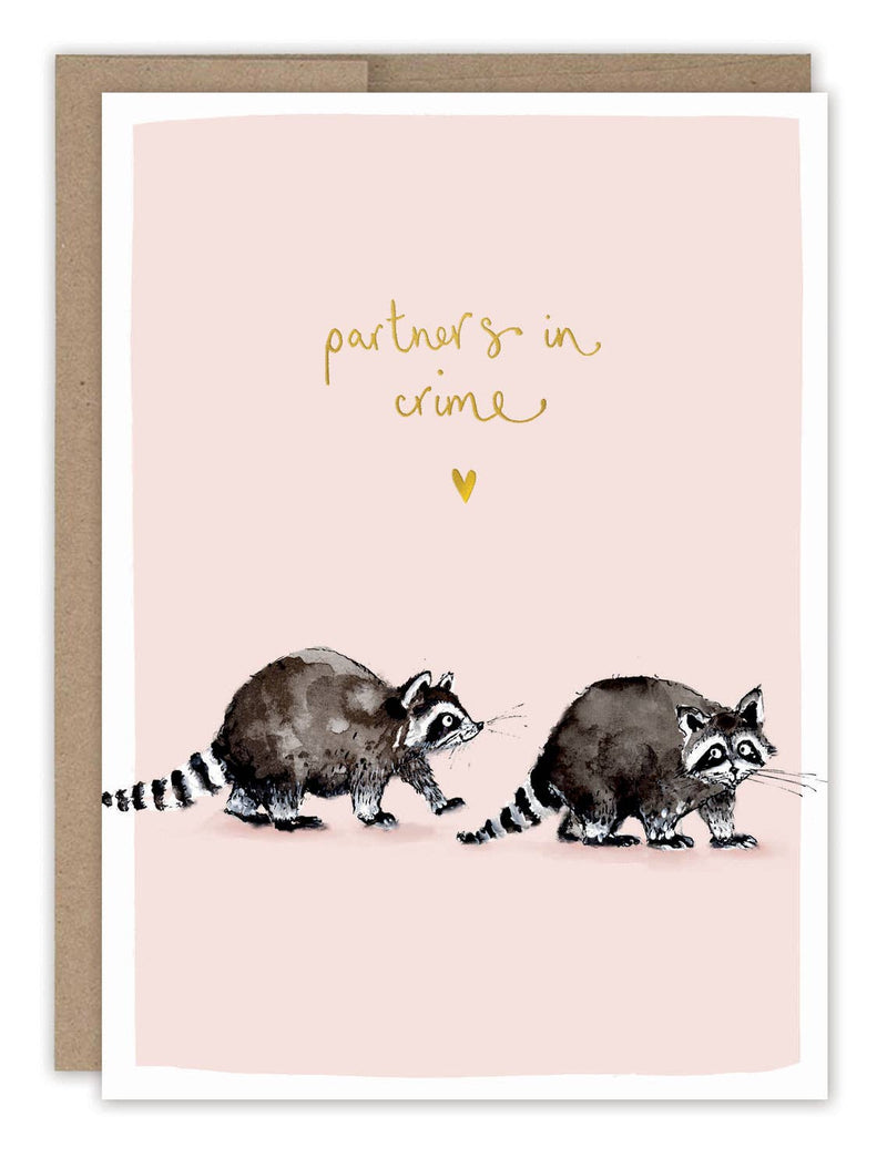 A pale pink card with two watercolor illustrated raccoons and the words "partners in crime" in gold foil.