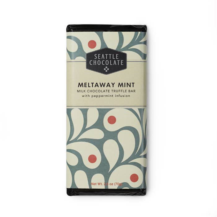 A Meltaway mint Milk Chocolate Truffle Bar with Peppermint Infusion wrapped in a  mint, cream, and red ornamental illustration.