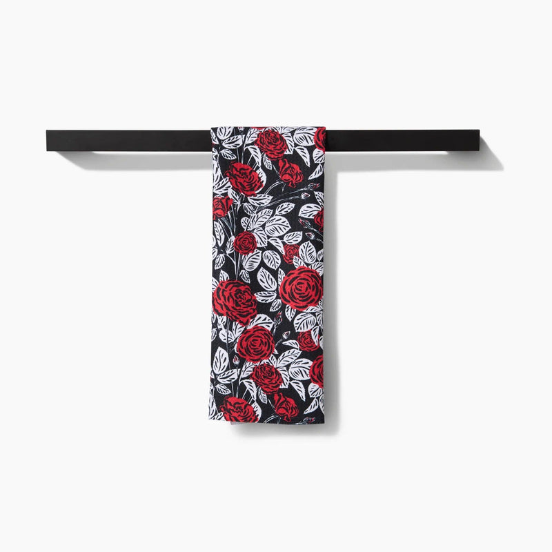 A Love and Roses Tea Towel hanging from a towel rack.