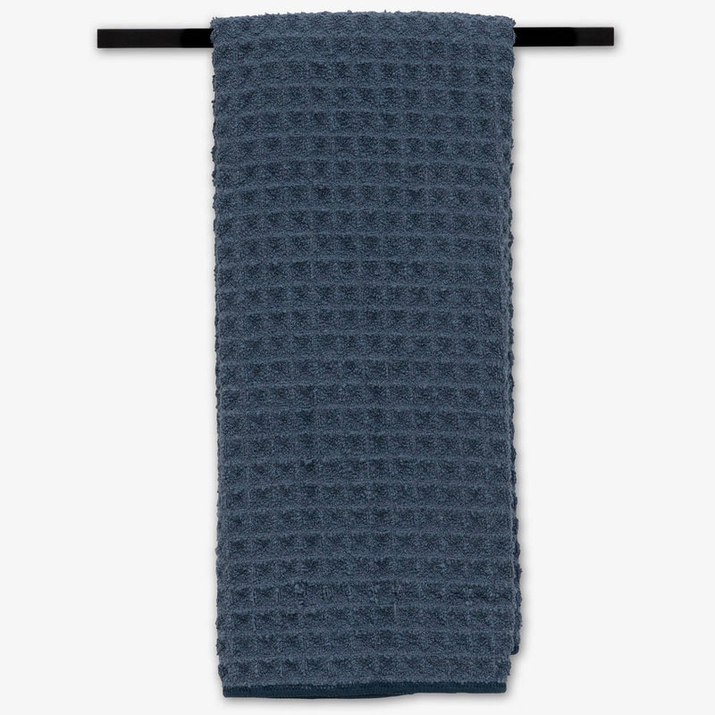 A Midnight Blue and Towel hanging on a towel rack.