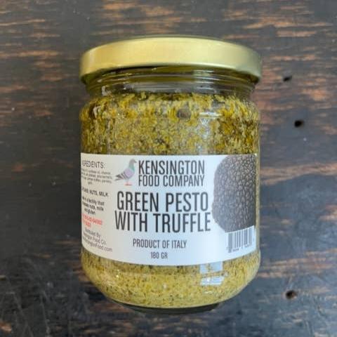 A clear jar filled with green pesto with truffle.