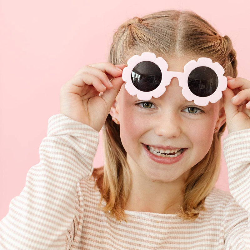 A young girl wearing the Shooting Star Stud Earrings and flower sunglasses.