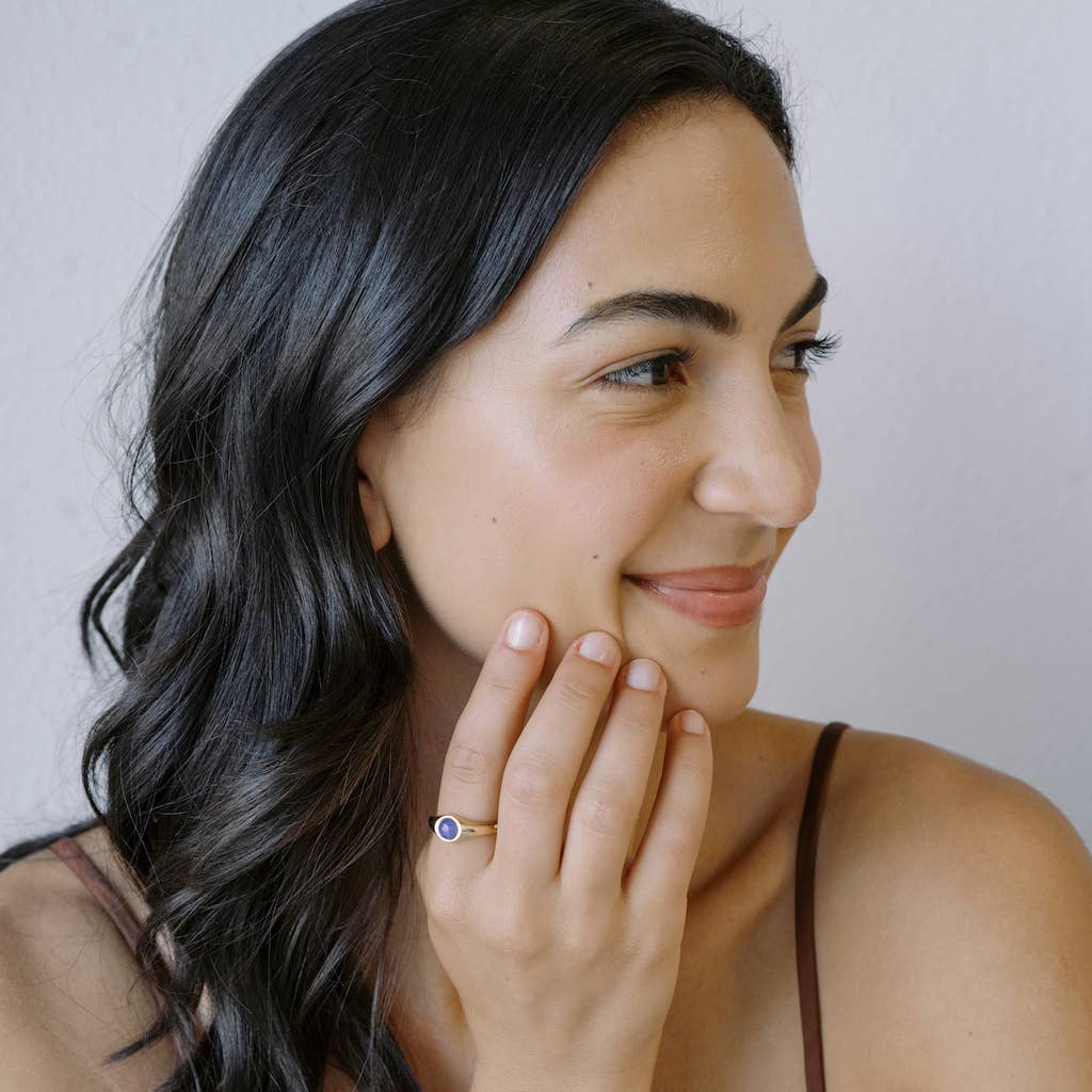 A person wearing a Signet Mood Ring in Gold on their pointer finger.