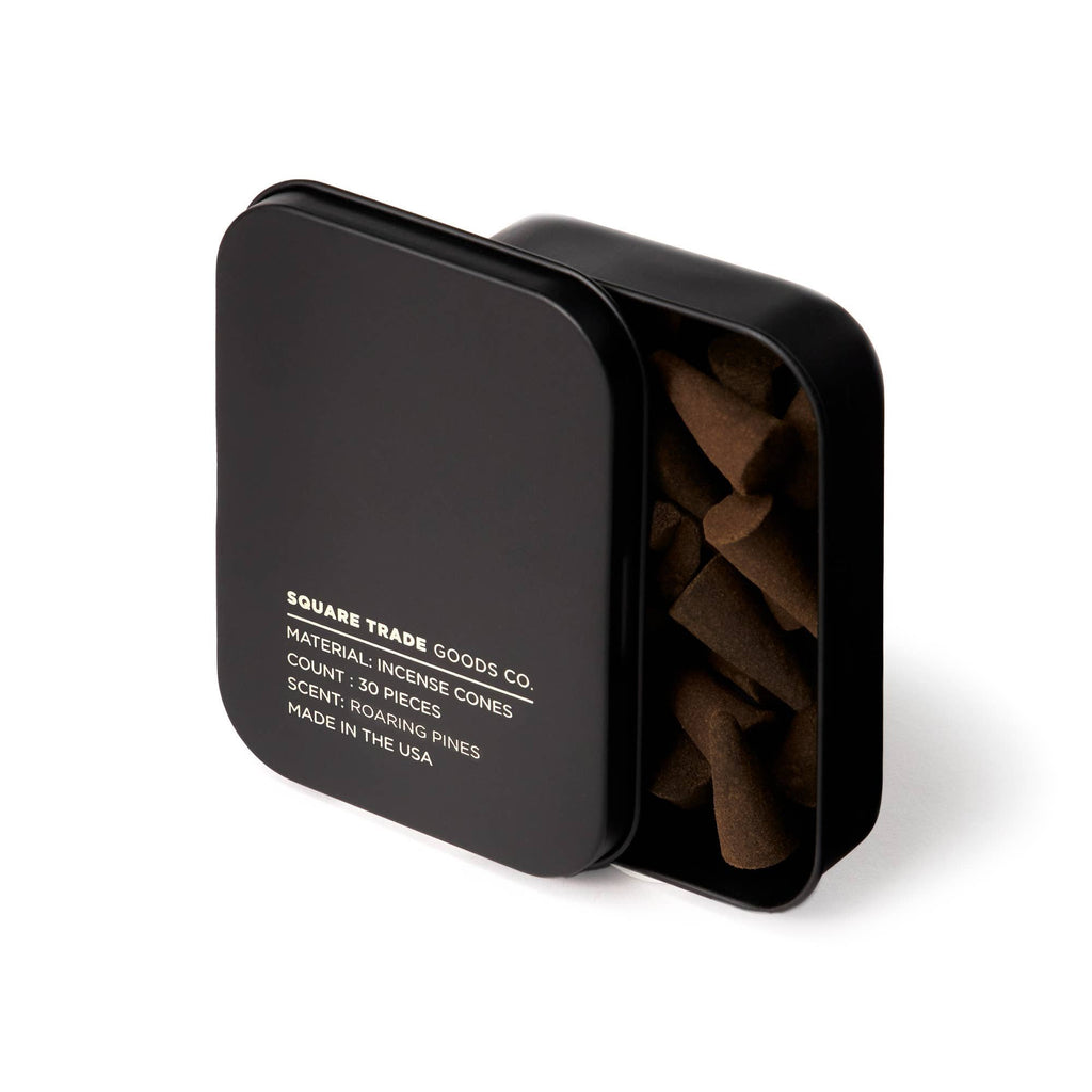 A matte black square tin filled with brown Roaring Pines Incense Cones.