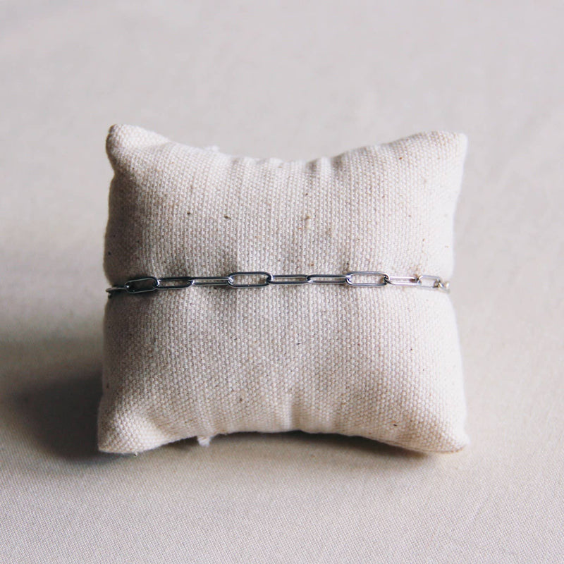 A D-Chain Bracelet hugging a linen pillow.