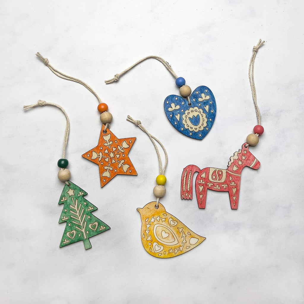 Five folk art ornaments including a horse, a tree, a star, a heart, and a bird.