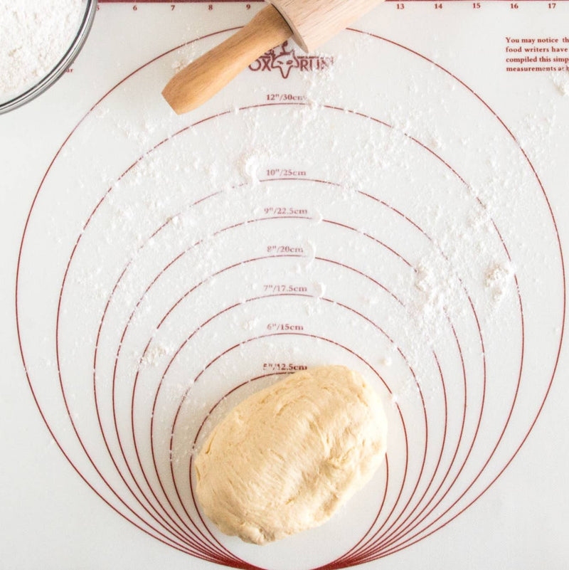 A bird's eye view of flour and a piece of dough on the circular measurements of the map.