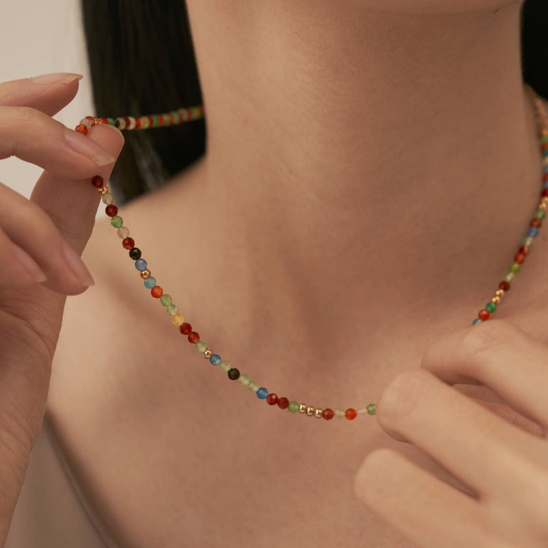 A person holding up the Rainbow Beaded Necklace.