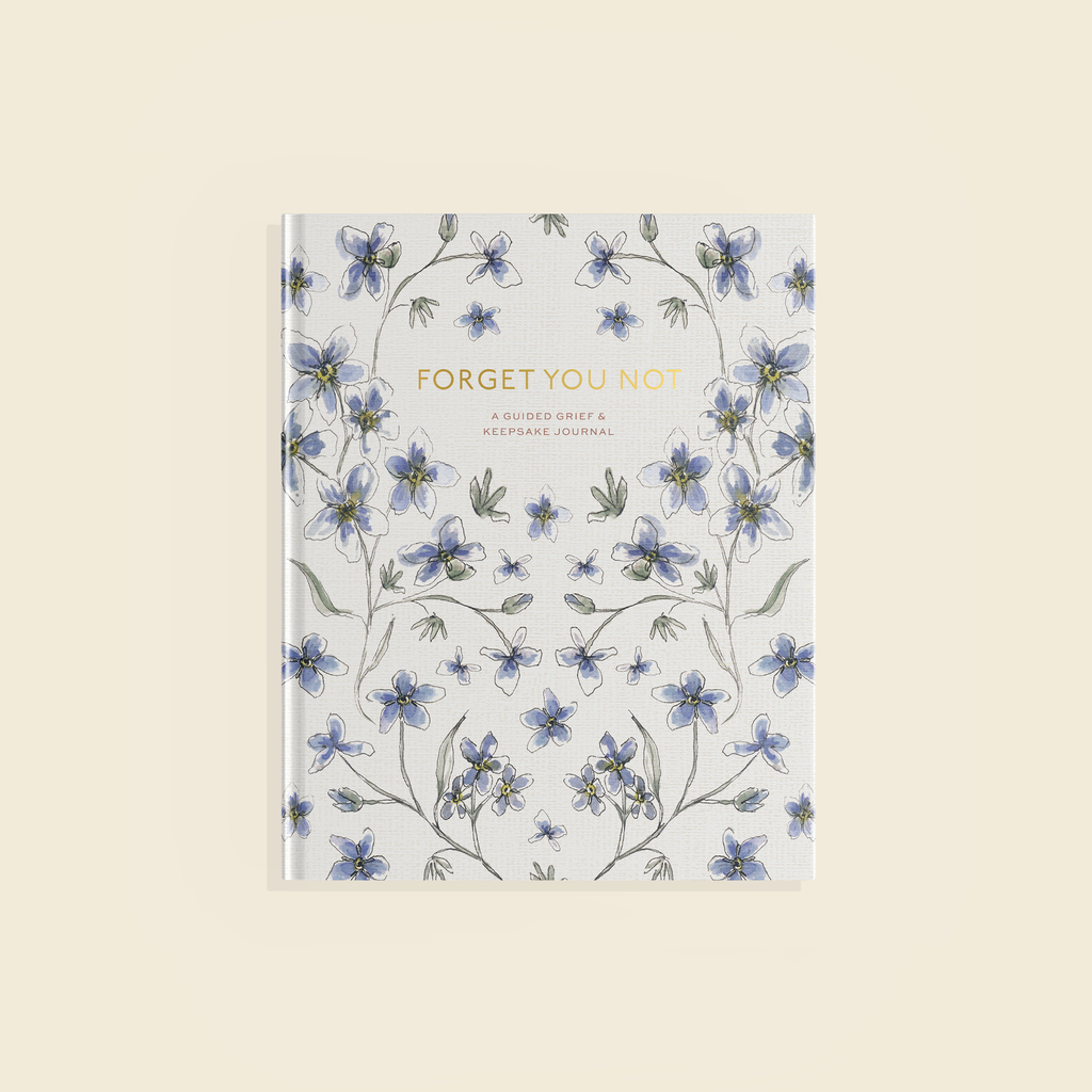 The book cover of Forget You Not, which features gold foil lettering and illustrations of indigo Forget-me-not flowers against a white background.