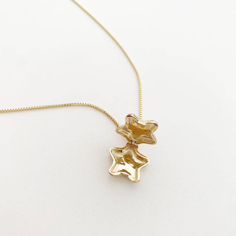 An open Polly Star Locket resting on a white table.