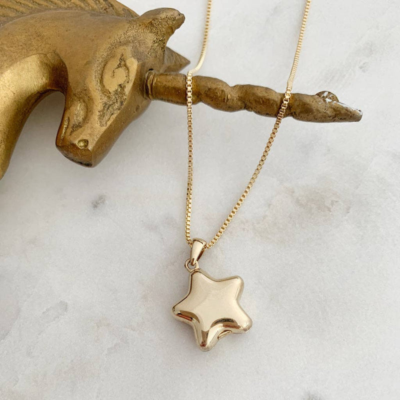 A gold rounded star locket pendant hanging from a fine box chain.