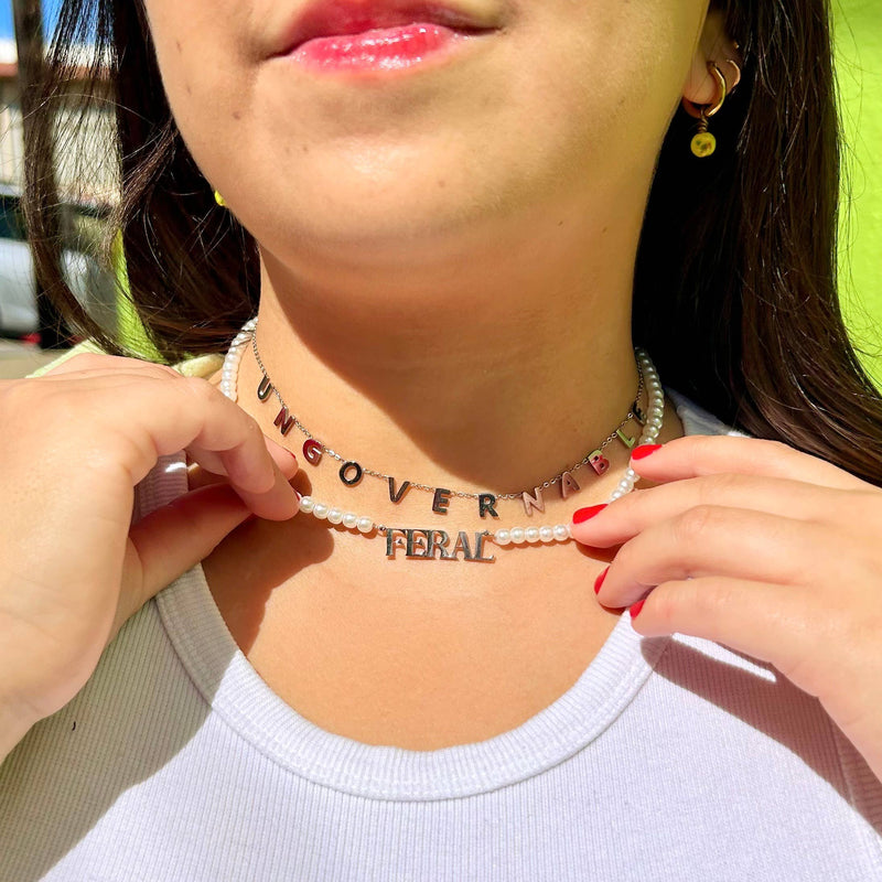 A person wearing the Feral Necklace in a necklace stack.