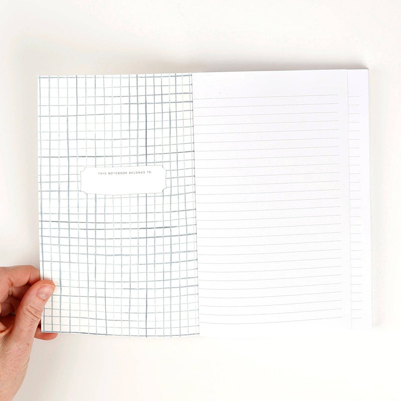 The inside front cover with watercolor painted blue grids and a place to write the notebook owner's name. The opposite side is white lined paper.