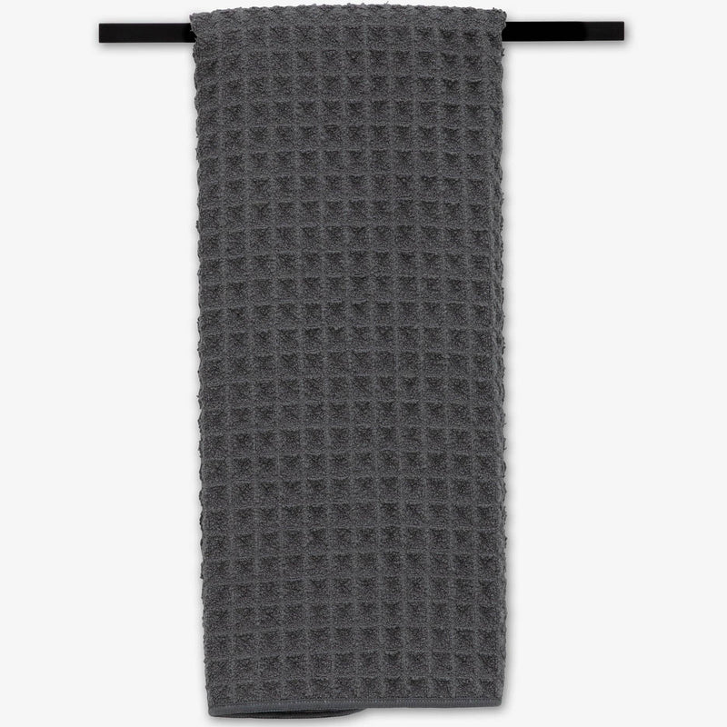 The Charcoal Waffle Hand Towel hanging from a towel rack.