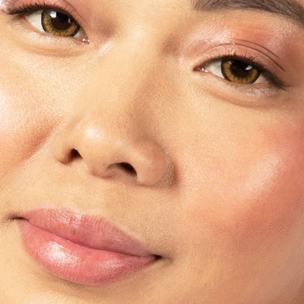 A person with medium light tone skin wearing Plum Delight on their eyes, cheekbones, and lips.