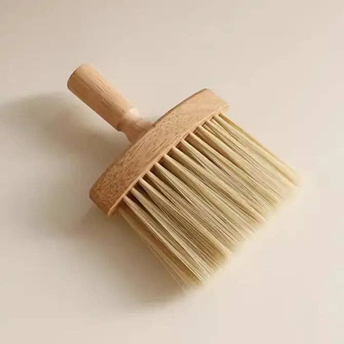 A wide wooden cleaning brush with long bristles.