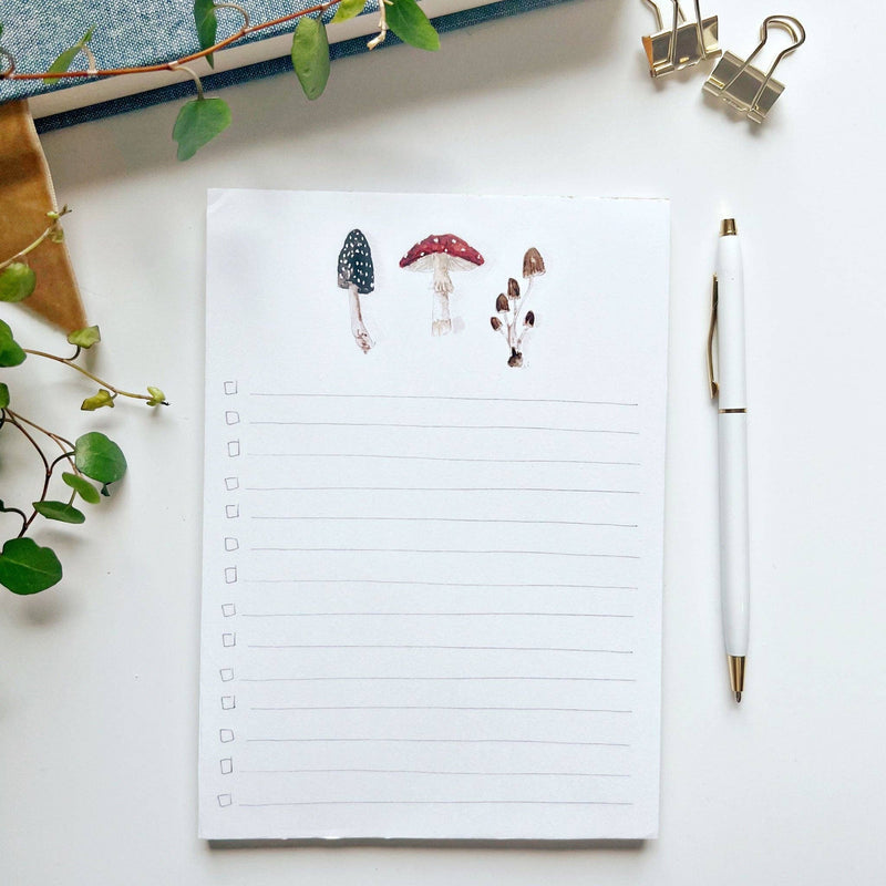 A notepad with a pencil style checklist  and three watercolor illustrated mushrooms.