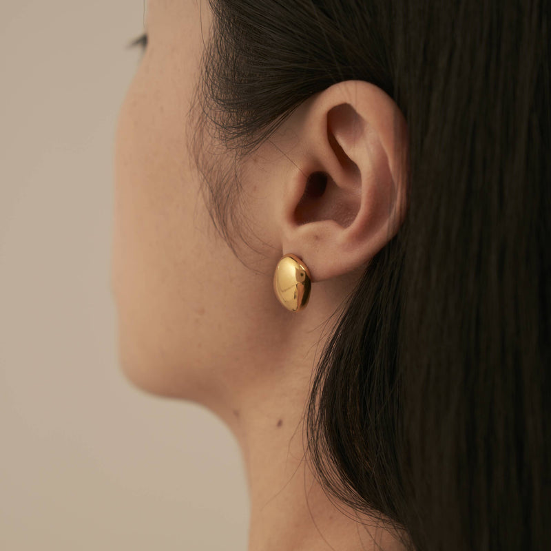 A person wearing the Glossy Square Stud Earrings.