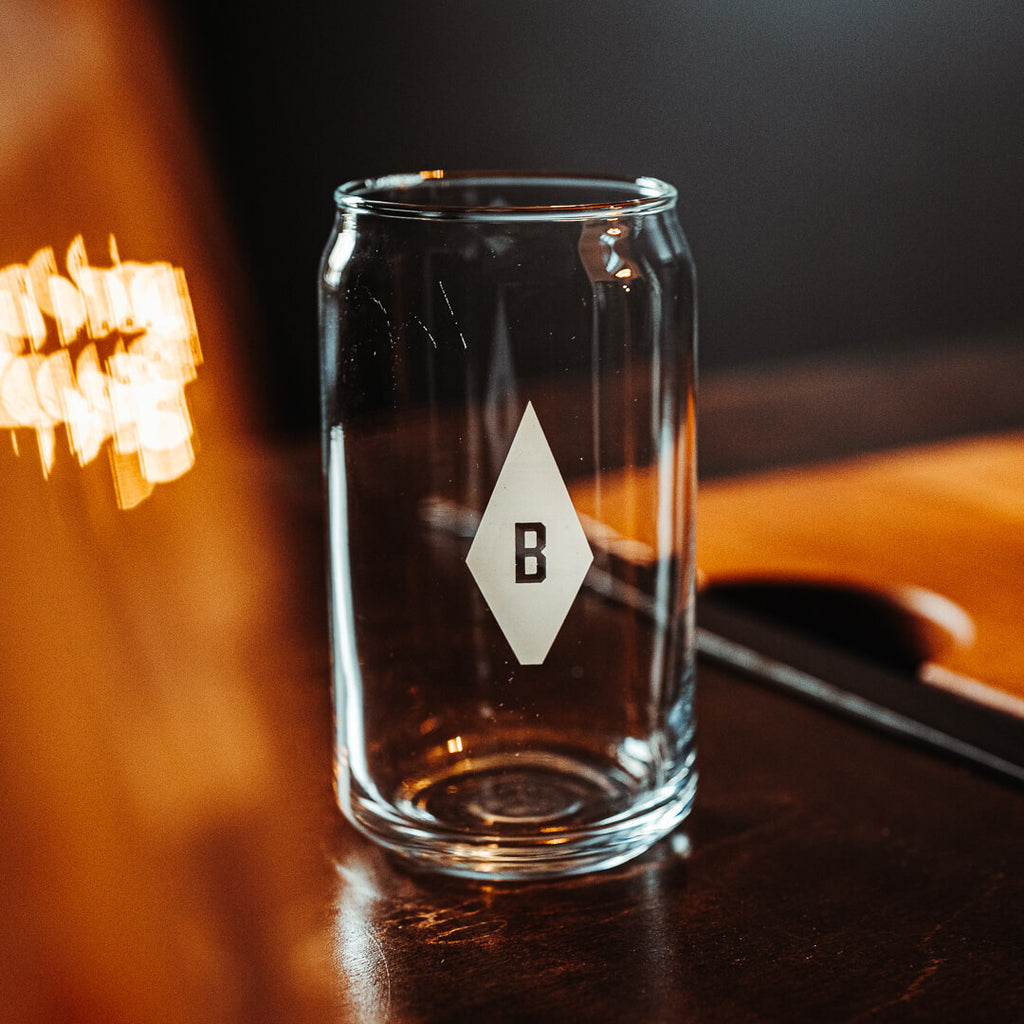 A clear glass cup in the shape of a beer can. It's engraved with a windmill counterweight and a "B".