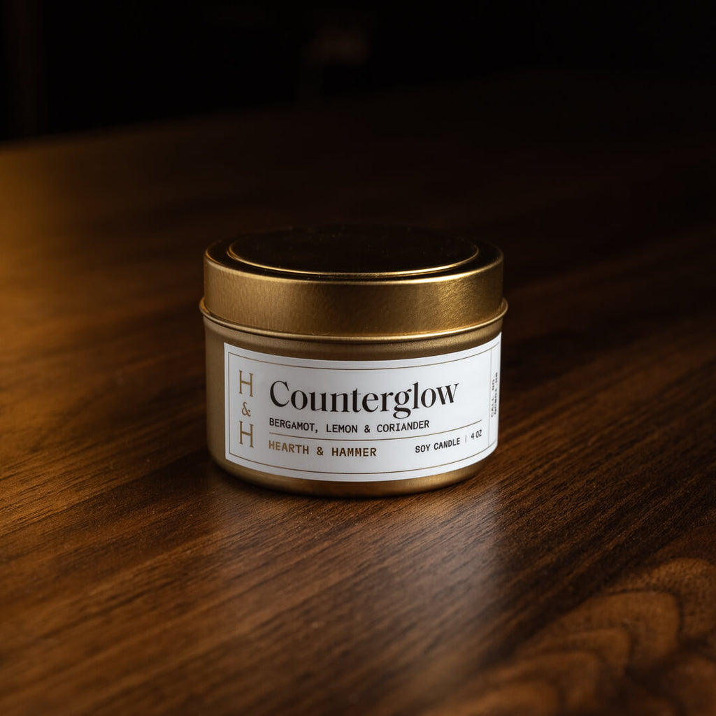 A closed Counterglow candle tin resting on a dark wooden table.