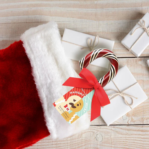 A Naughty or Nice Candy Cane peeking out of a stocking.