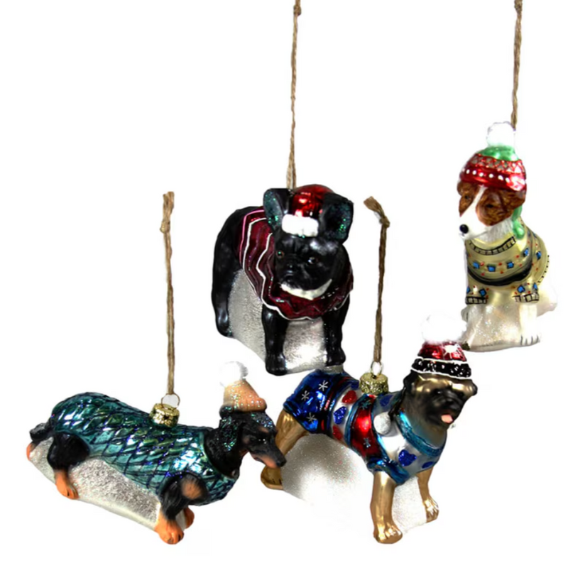 Four dogs bundled in sweaters and hats ornaments: a black French Bulldog, a white and brown mutt, a black and brown Dachshund, and a tan and black Mastiff.