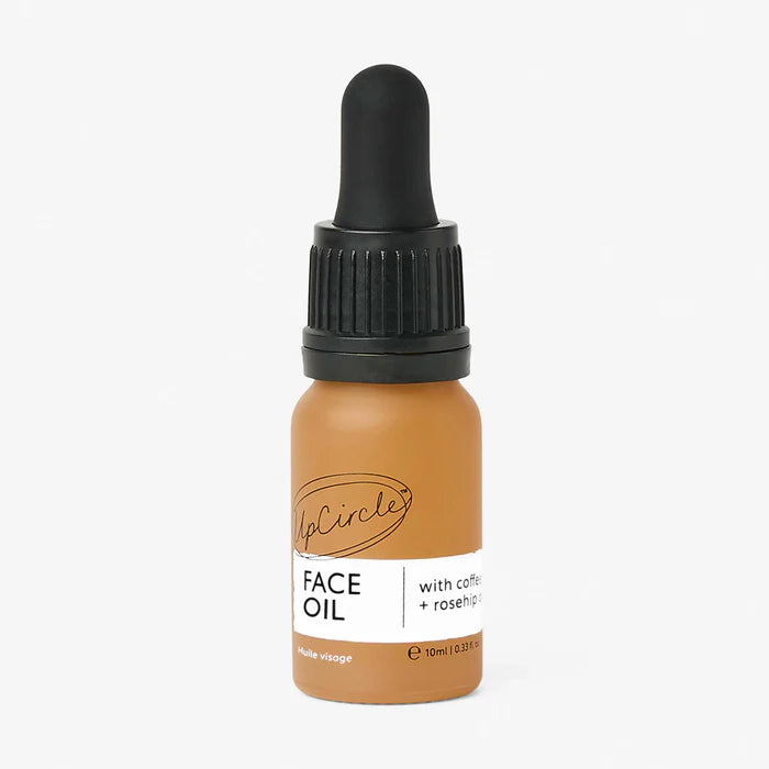 An orange bottle of Travel Size Face Oil with a black dropper cap.