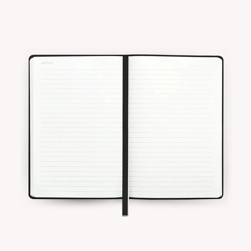 A notebook laid flat with lined pages and the word "notes" in the top left corner. There is a black ribbon bookmark along the center.