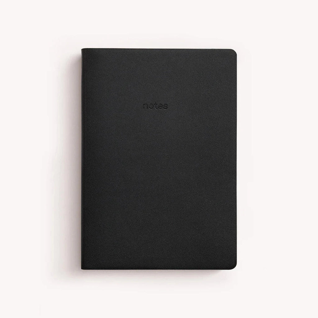 A black vegan leather notebook embossed with "notes" in the middle.