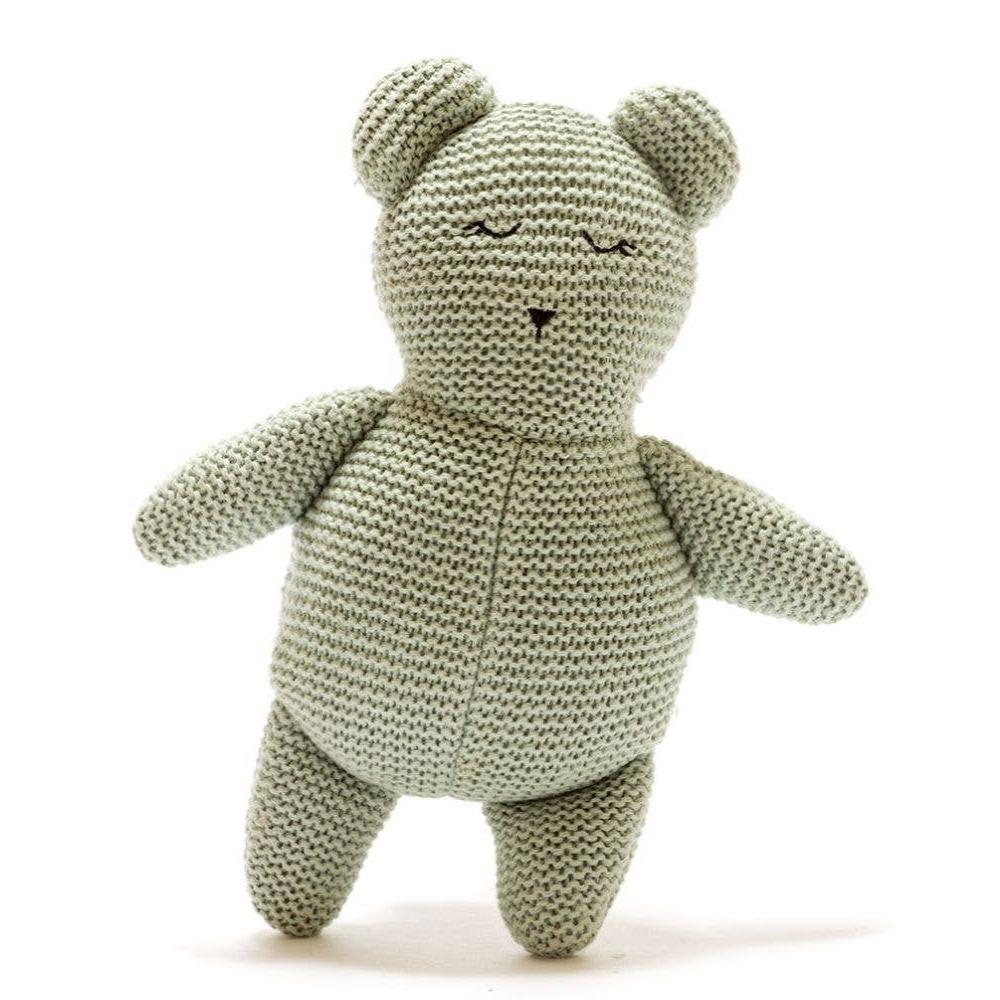 A sage green knitted teddy bear plush with embroidered closed eyes.