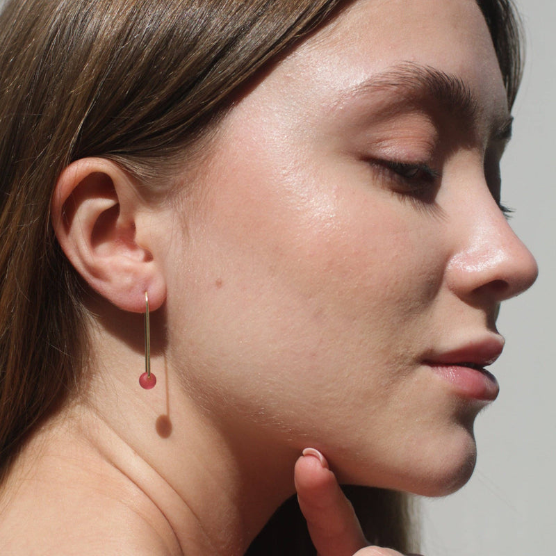 A person wearing the Sea Glass Threader earrings in Rosé.